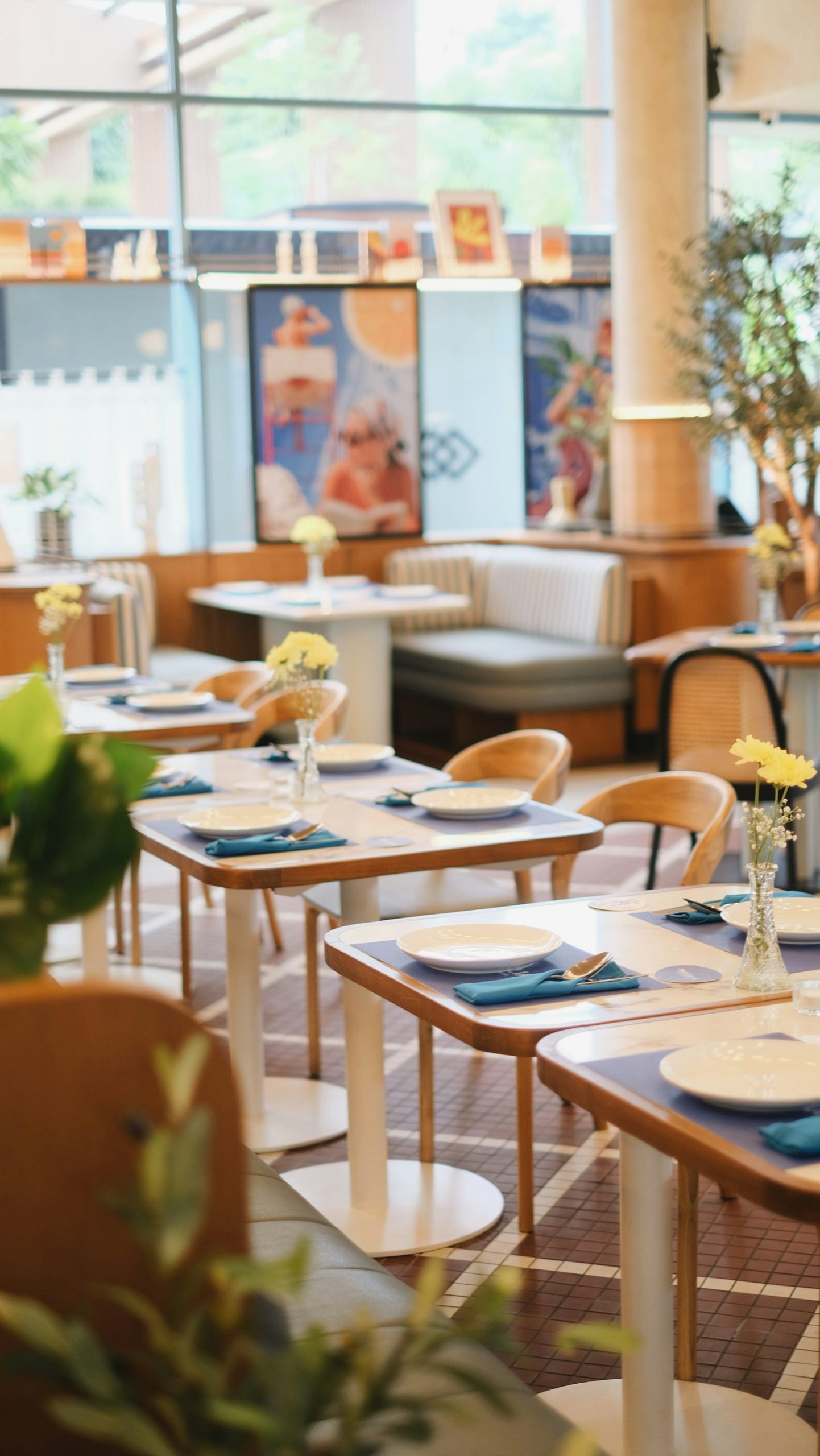 Bright restaurant dining room with set tables, chairs and flowers