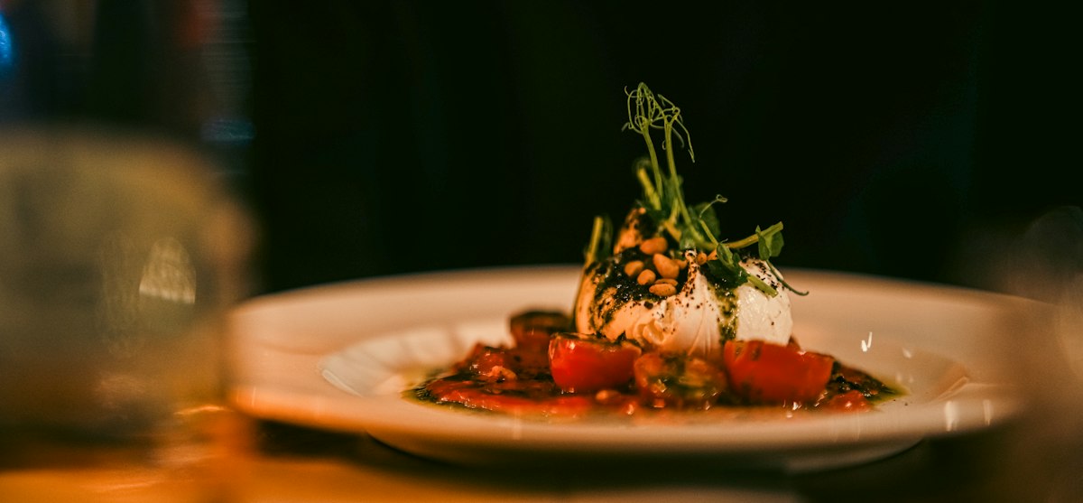Burrata with tomatoes and fresh herbs on a plate