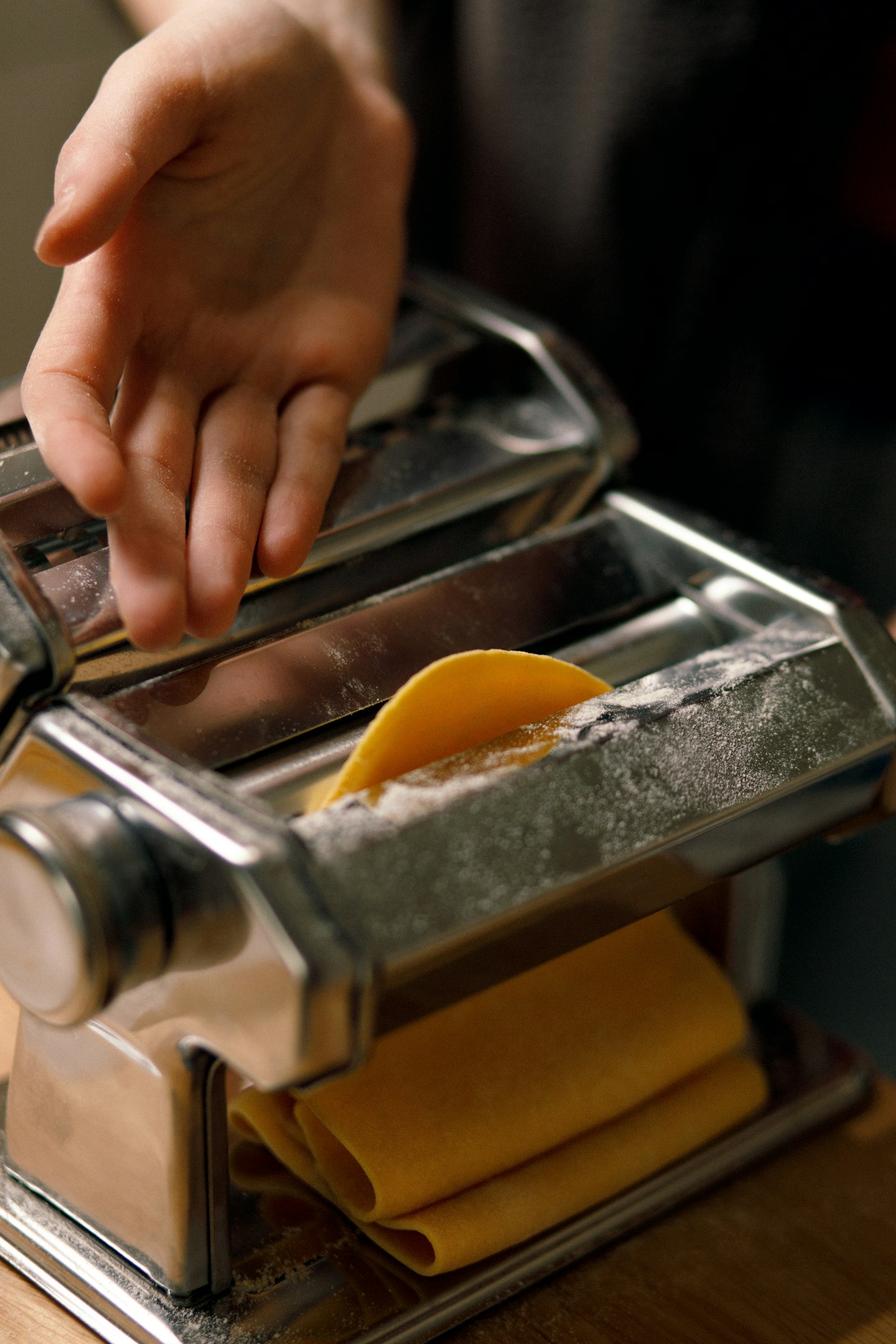 Pasta sheet being cut into ribbons with a pasta cutter
