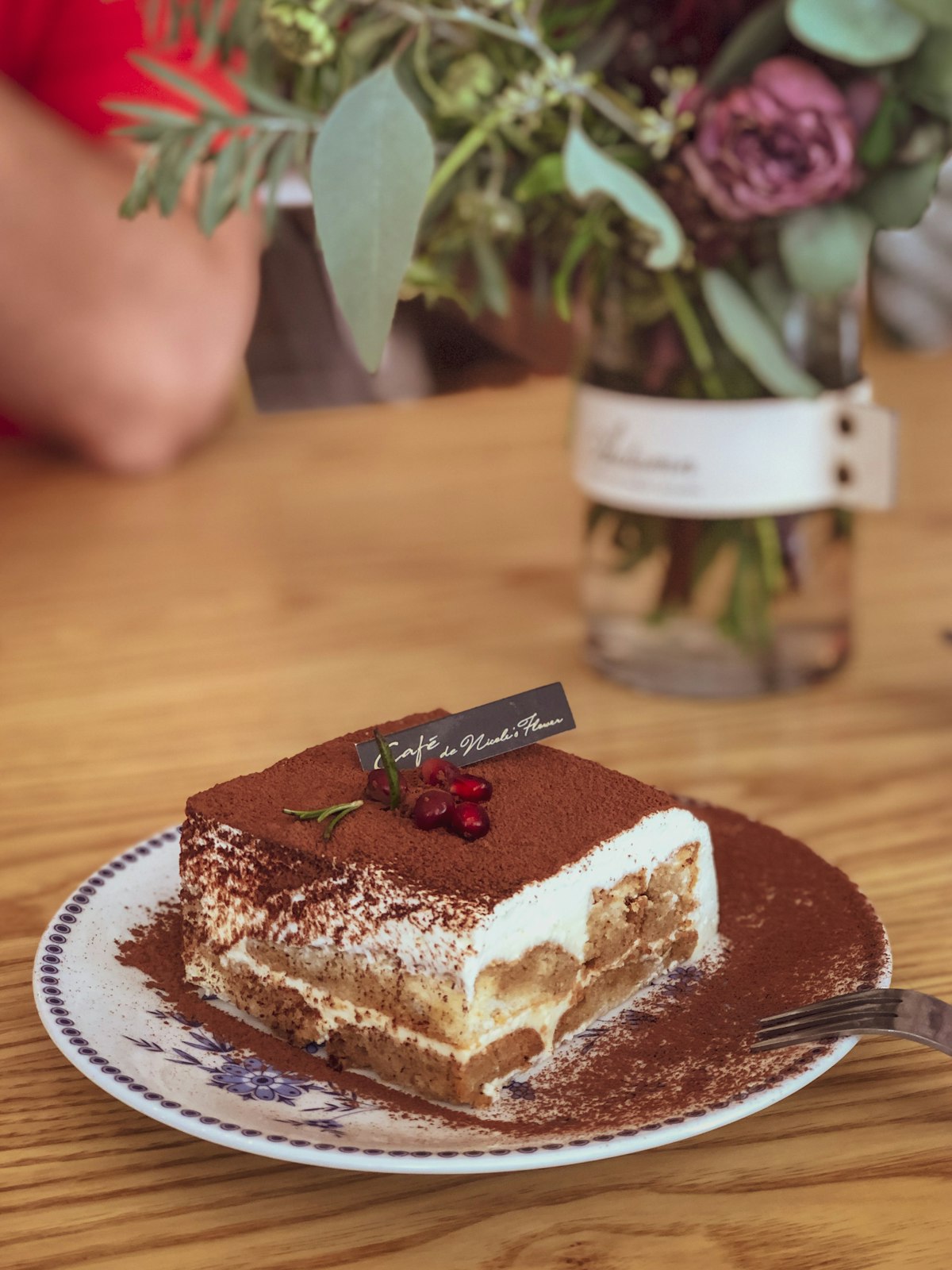 Slice of layered tiramisu dusted with cocoa