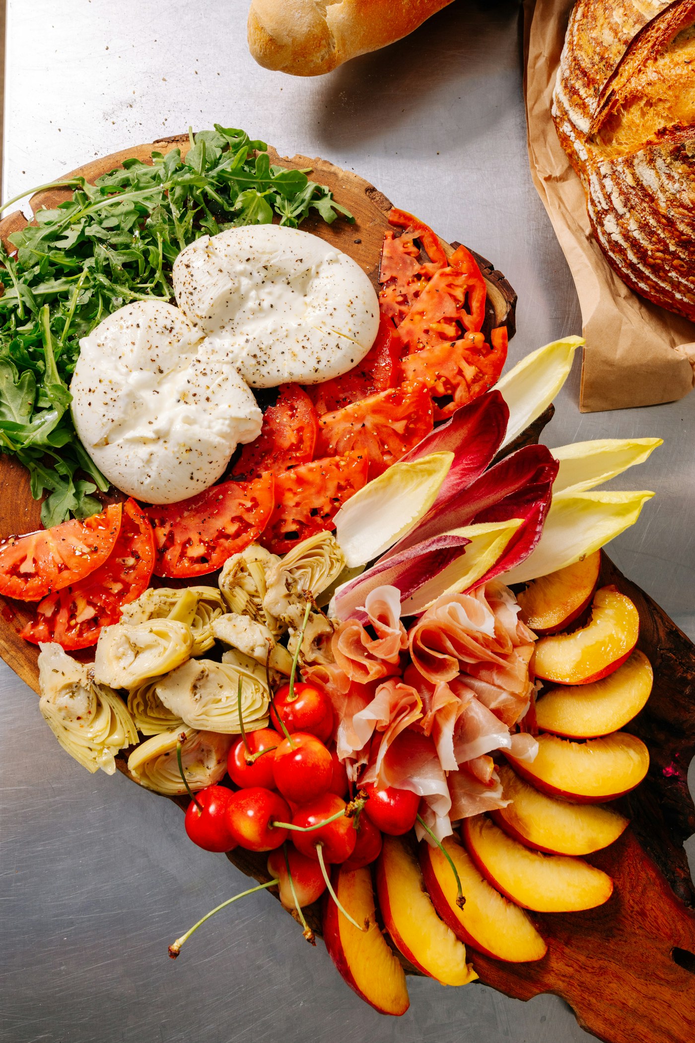 Rustic board with burrata, tomatoes, cured meats and fresh produce