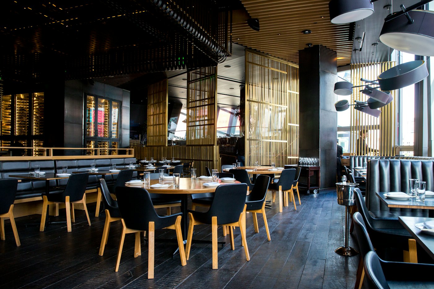 Warmly lit restaurant dining room with wooden tables and chairs